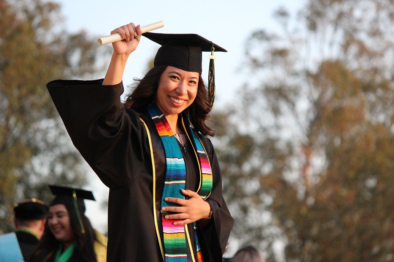 Female graduate holding up diploma